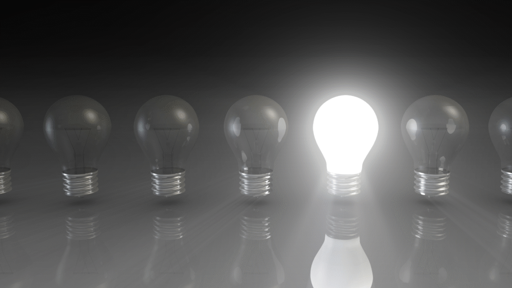Glowing light bulb among unlit bulbs